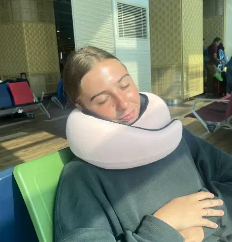 Aisha N. using the FlyHugz® travel pillow